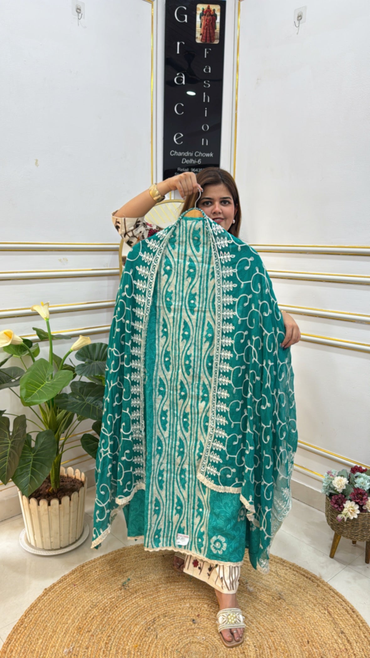 Model showcasing an unstitched cotton suit set in teal with intricate white embroidery