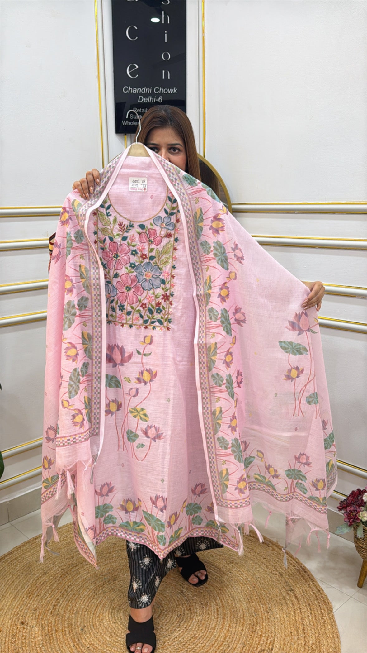 Woman showcasing a beautiful linen Jamdhani suit with floral embroidery and a light pink color