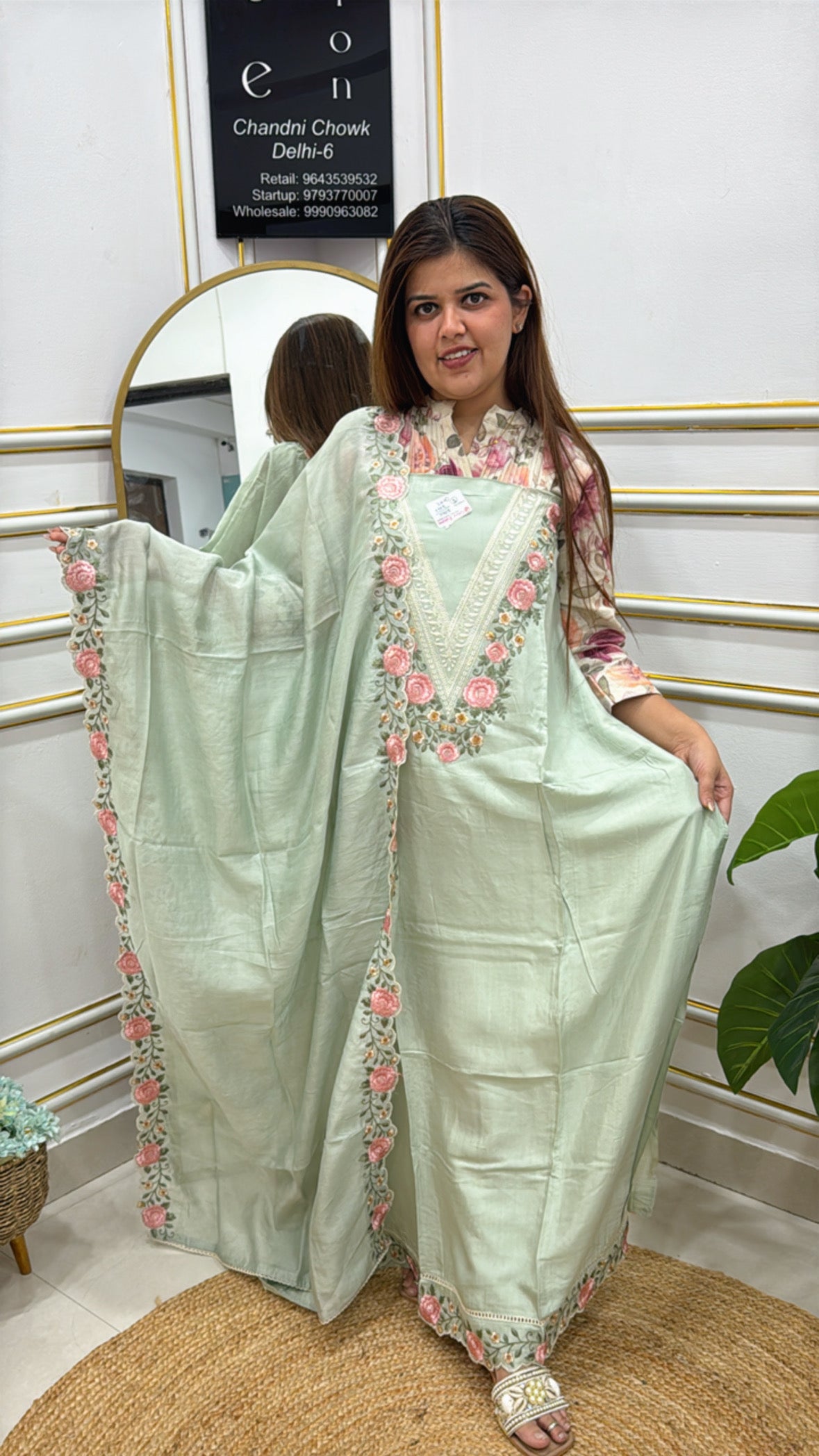 Elegant model wearing modal cotton designer suits with floral embroidery in pastel green color