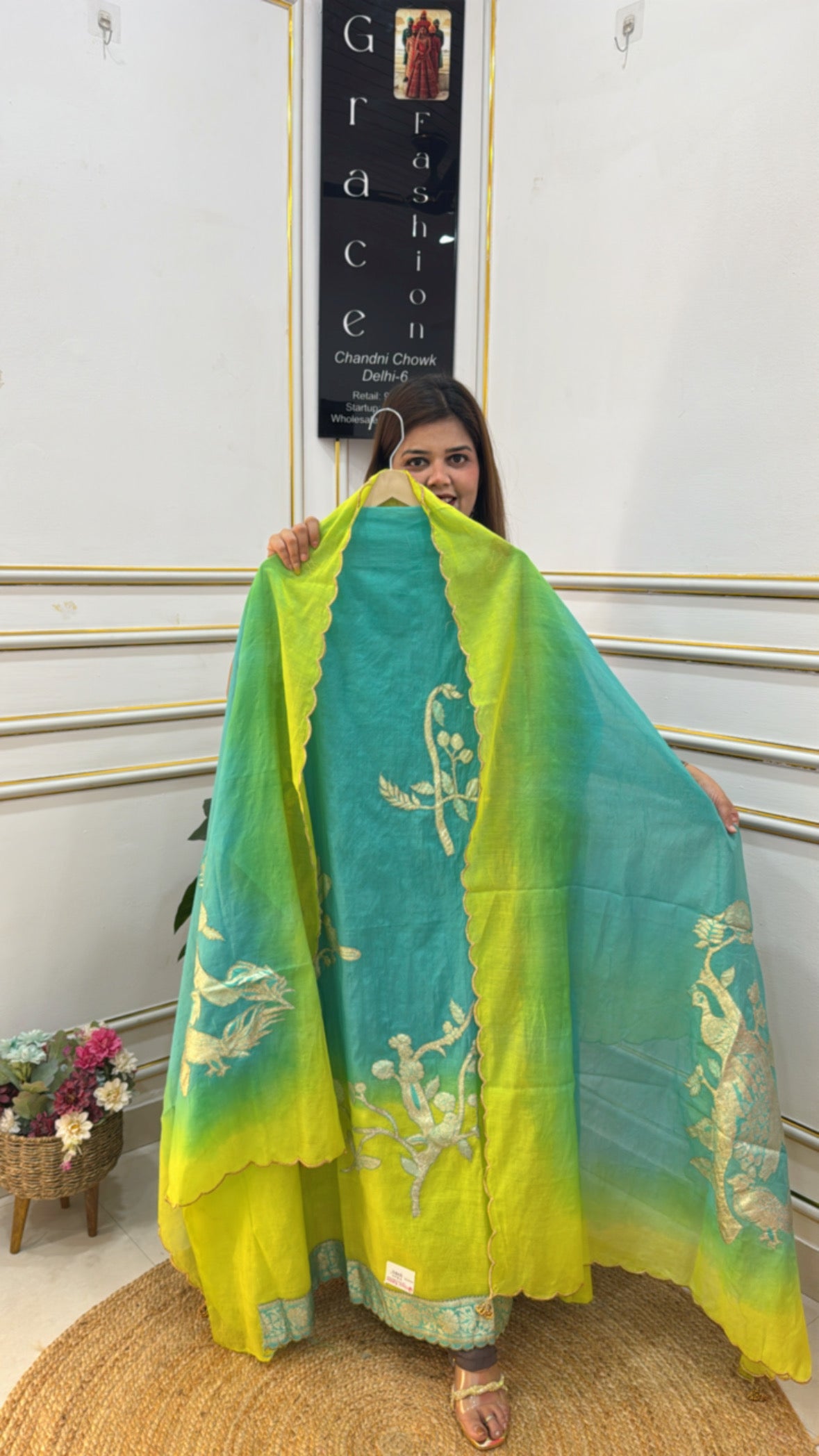 Model showcasing an ombre cotton silk suit in vibrant blue and green with intricate embroidery