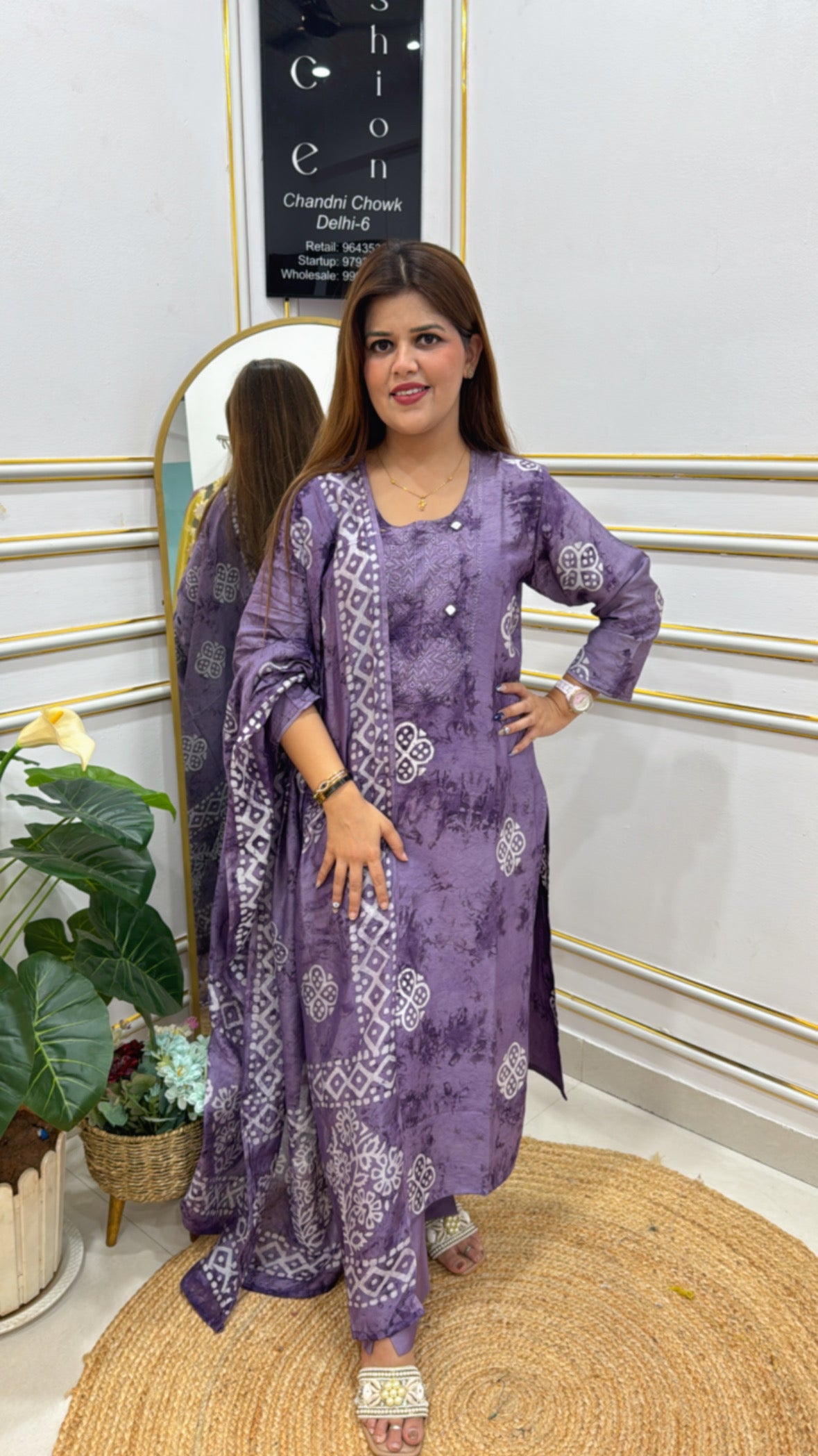 Elegant model showcasing a premium batik shibori dress in purple with intricate patterns and stylish design.