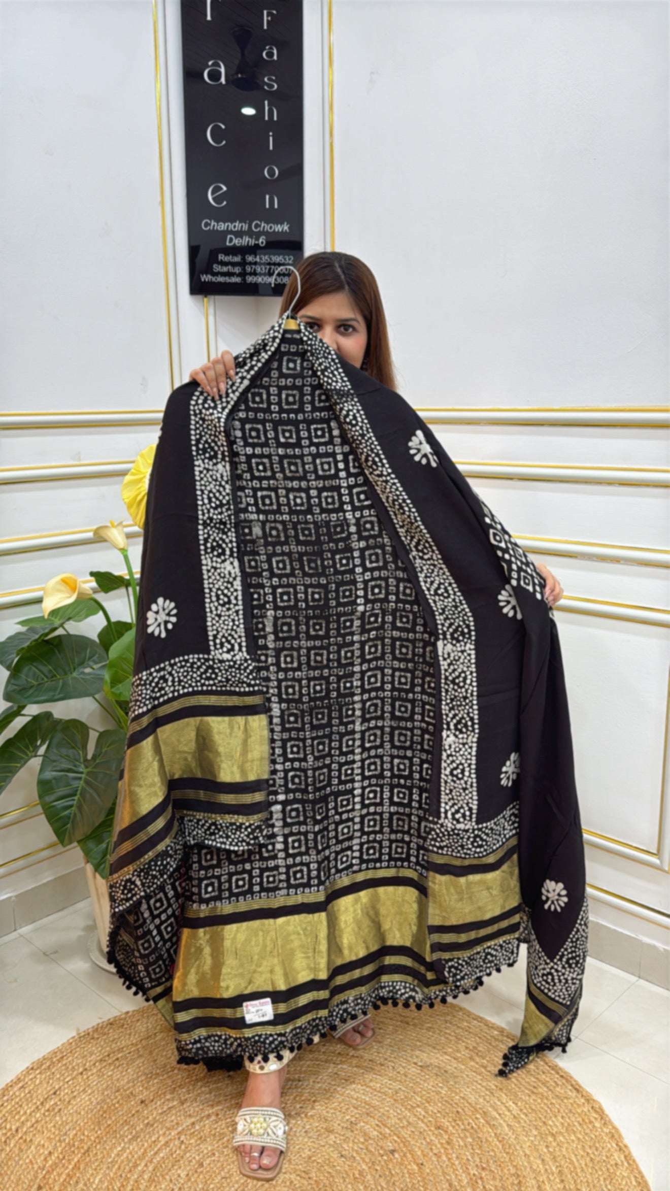 Elegant premium batik suits in black with intricate patterns and golden accents showcased by a model