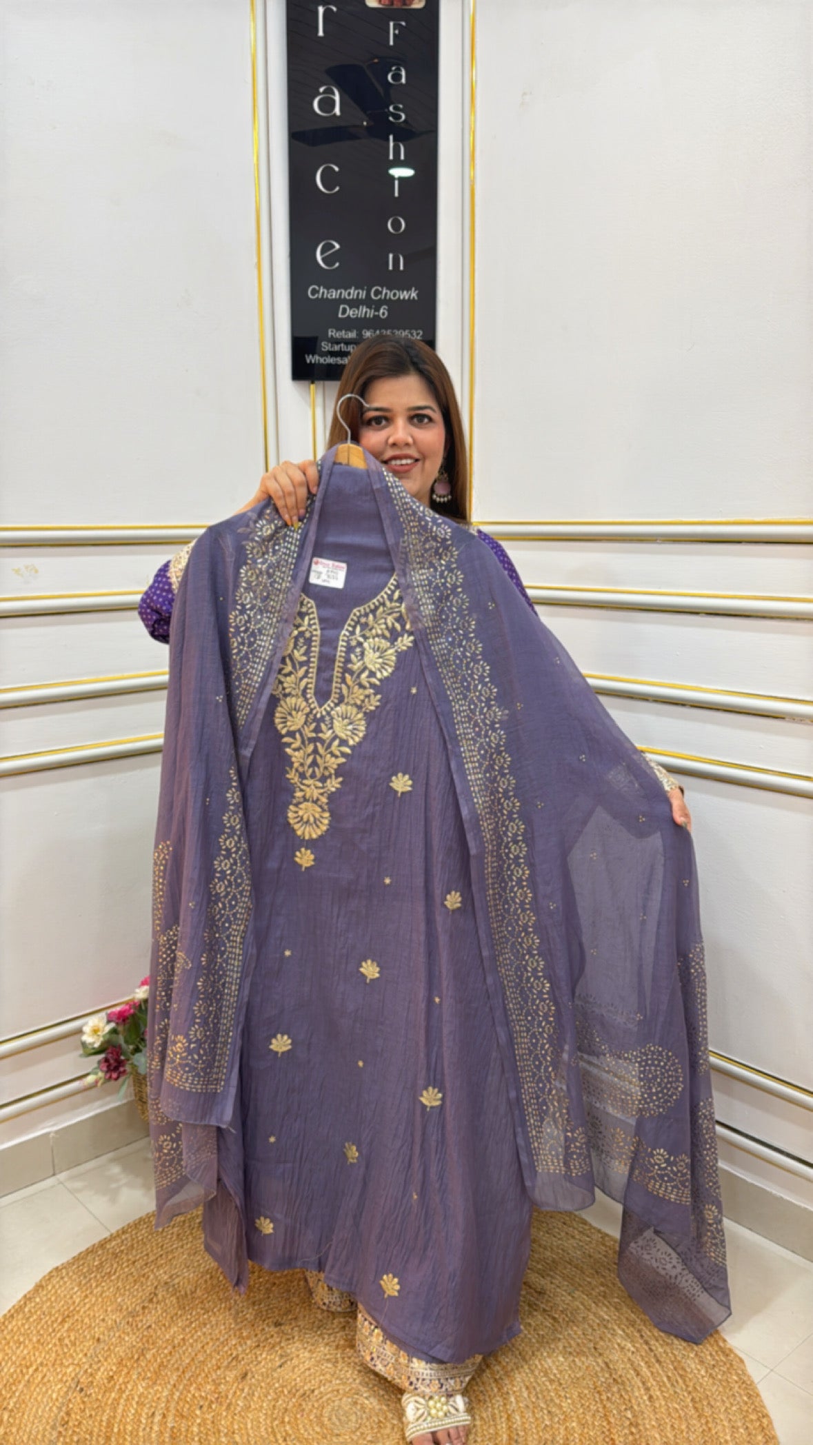 Woman showcasing a stunning purple dress made from premium cotton silk fabric with intricate gold embroidery