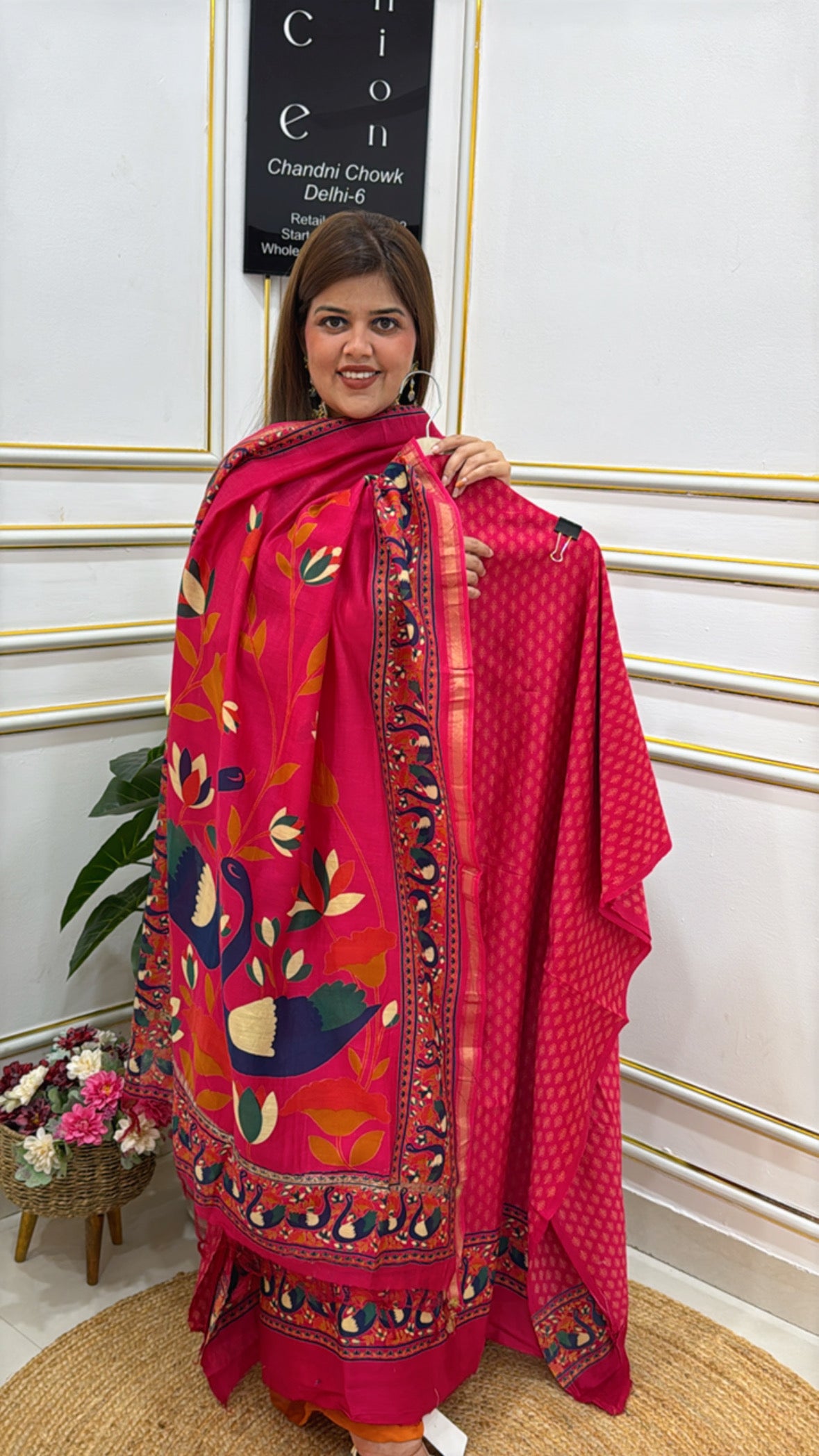 Elegant model showcasing a vibrant pink premium cotton silk suit with intricate floral patterns