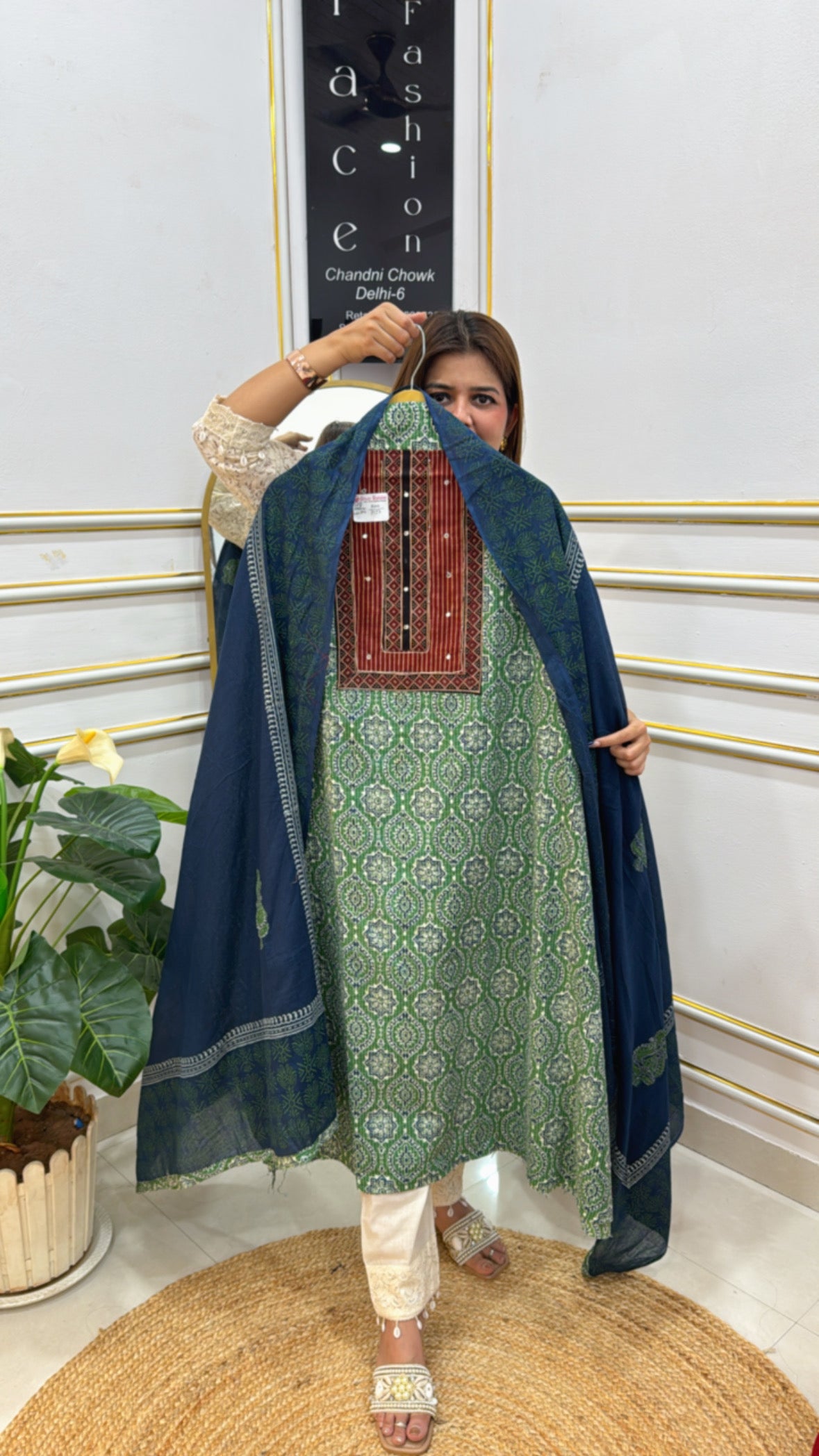 Elegant model showcasing a premium cotton unstitched suit with intricate green and navy designs