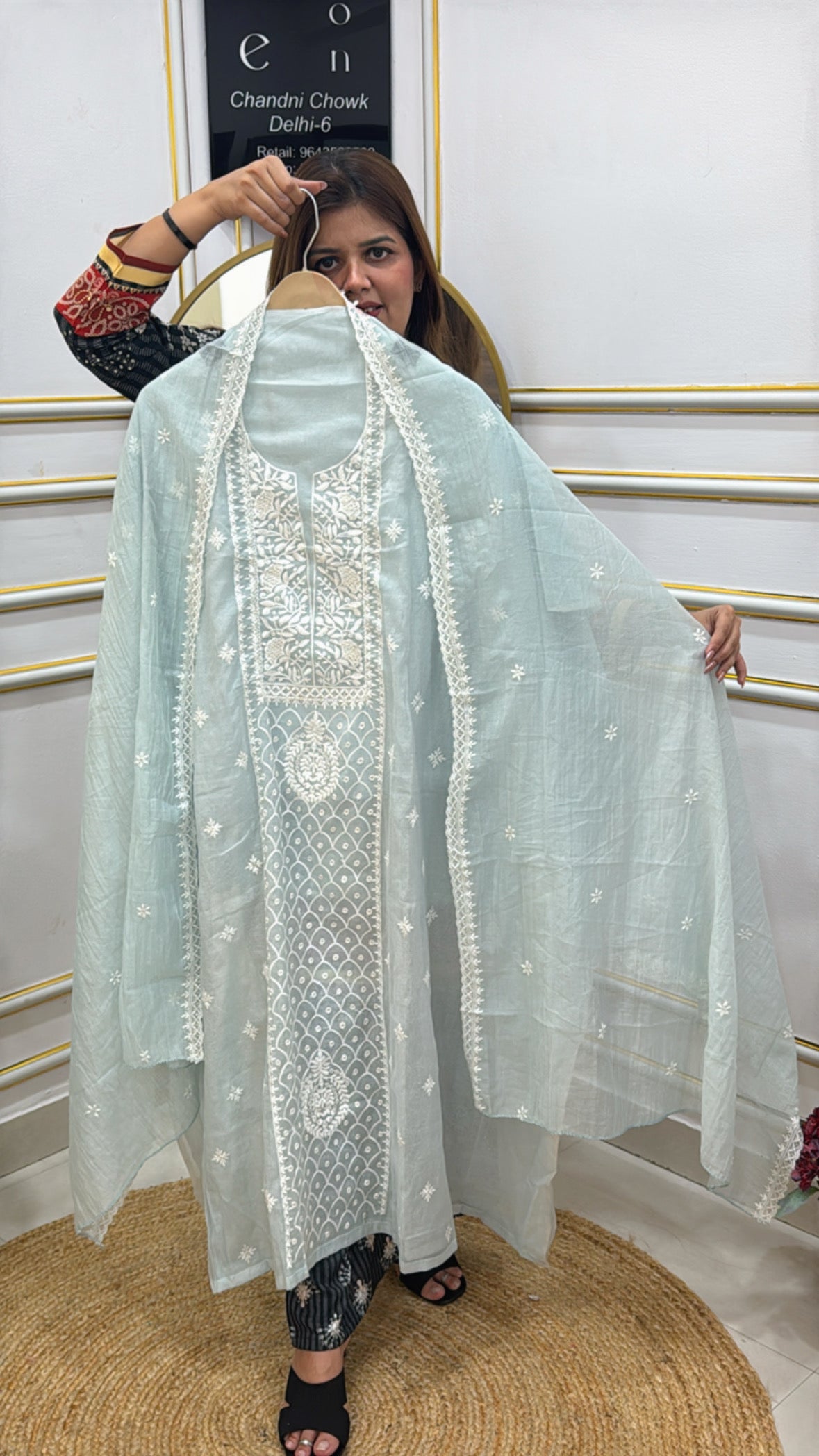 Stylish model showcasing a premium embroidered cotton silk suit with delicate embroidery and matching shawl