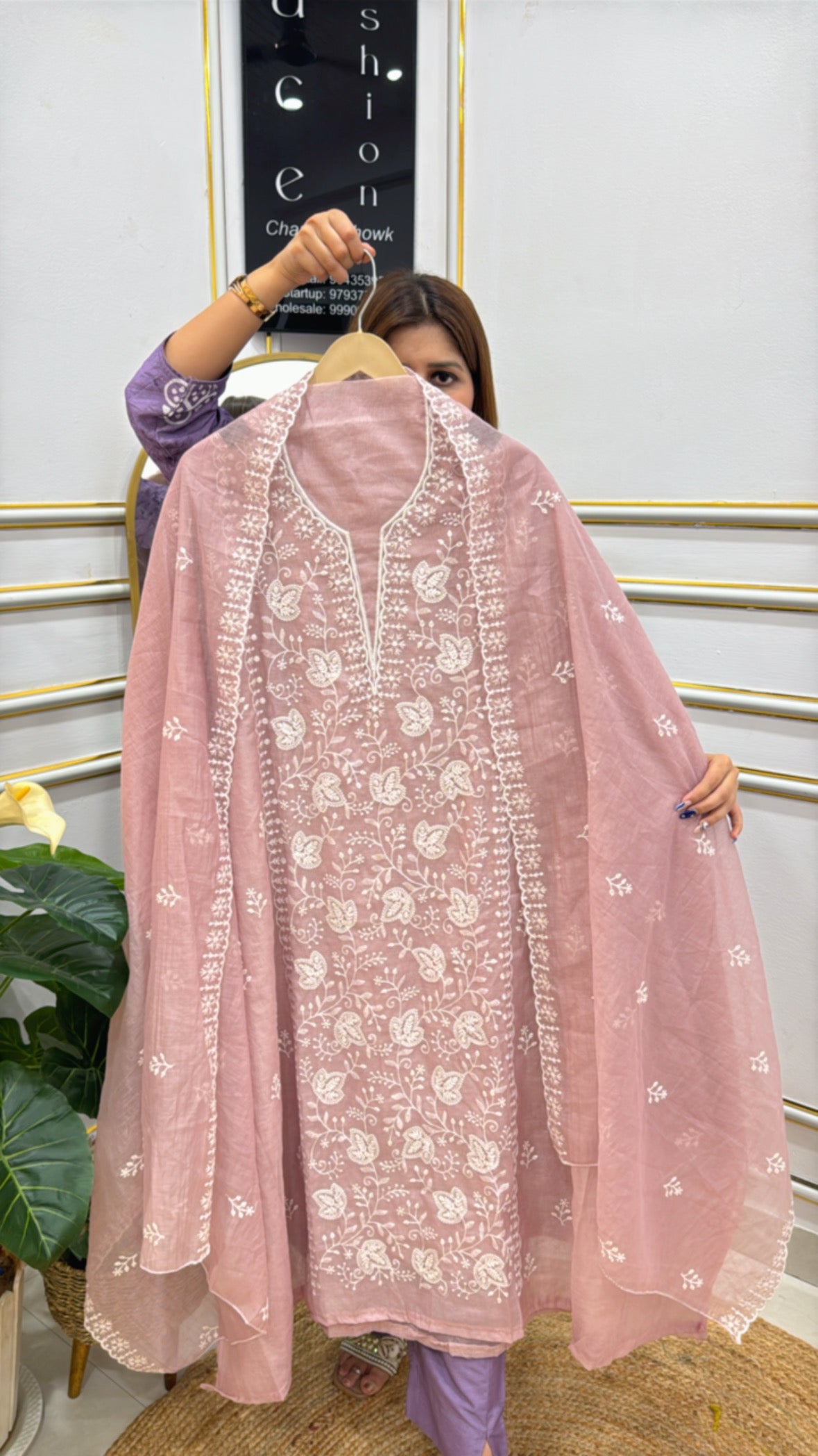 Elegant model showcasing a premium embroidered cotton silk suit with intricate floral designs in soft pink