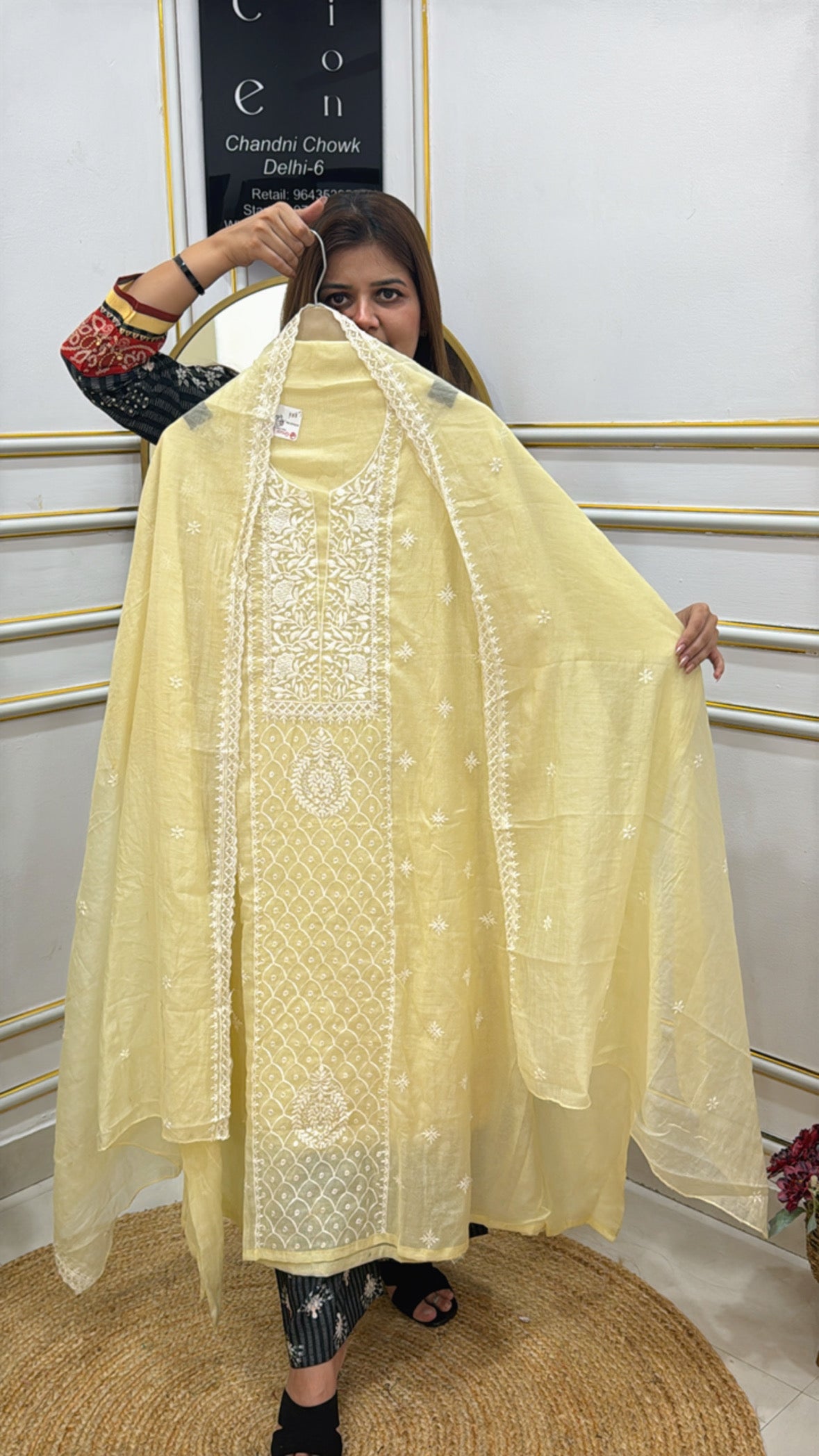 Model showcasing a premium embroidered cotton silk suit in soft yellow with intricate designs