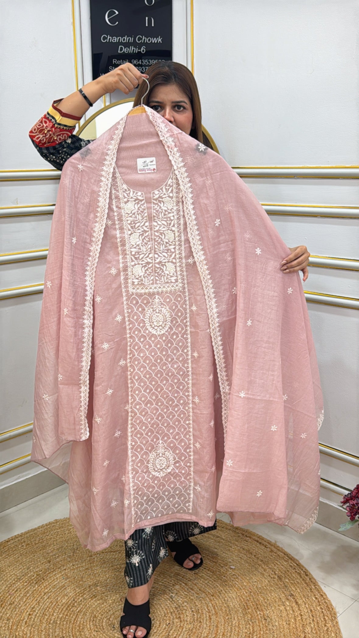 Model showcasing a premium embroidered cotton silk suit in soft pink with intricate designs and matching dupatta