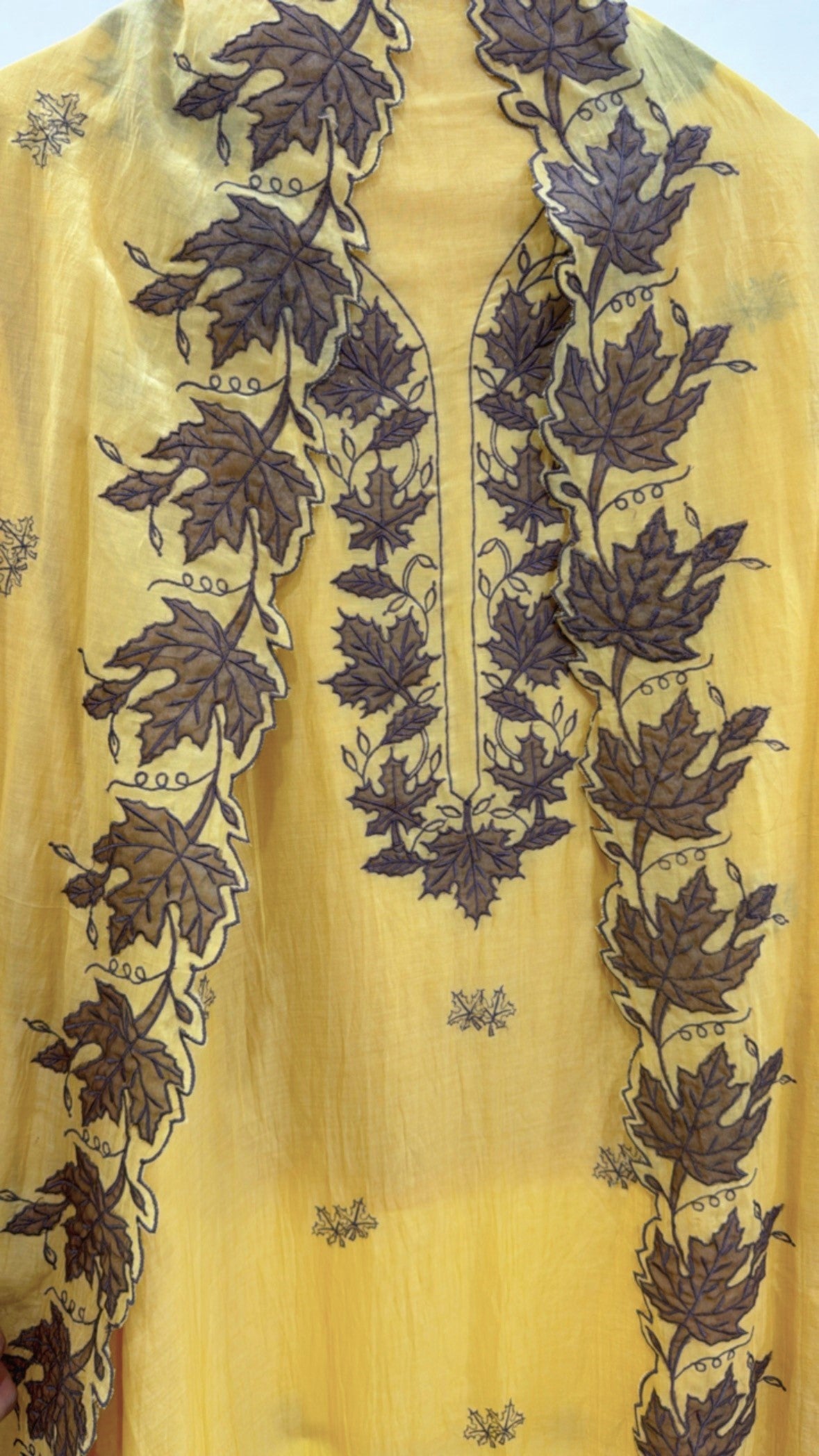 Premium embroidered ladies suits in yellow fabric featuring intricate leaf designs