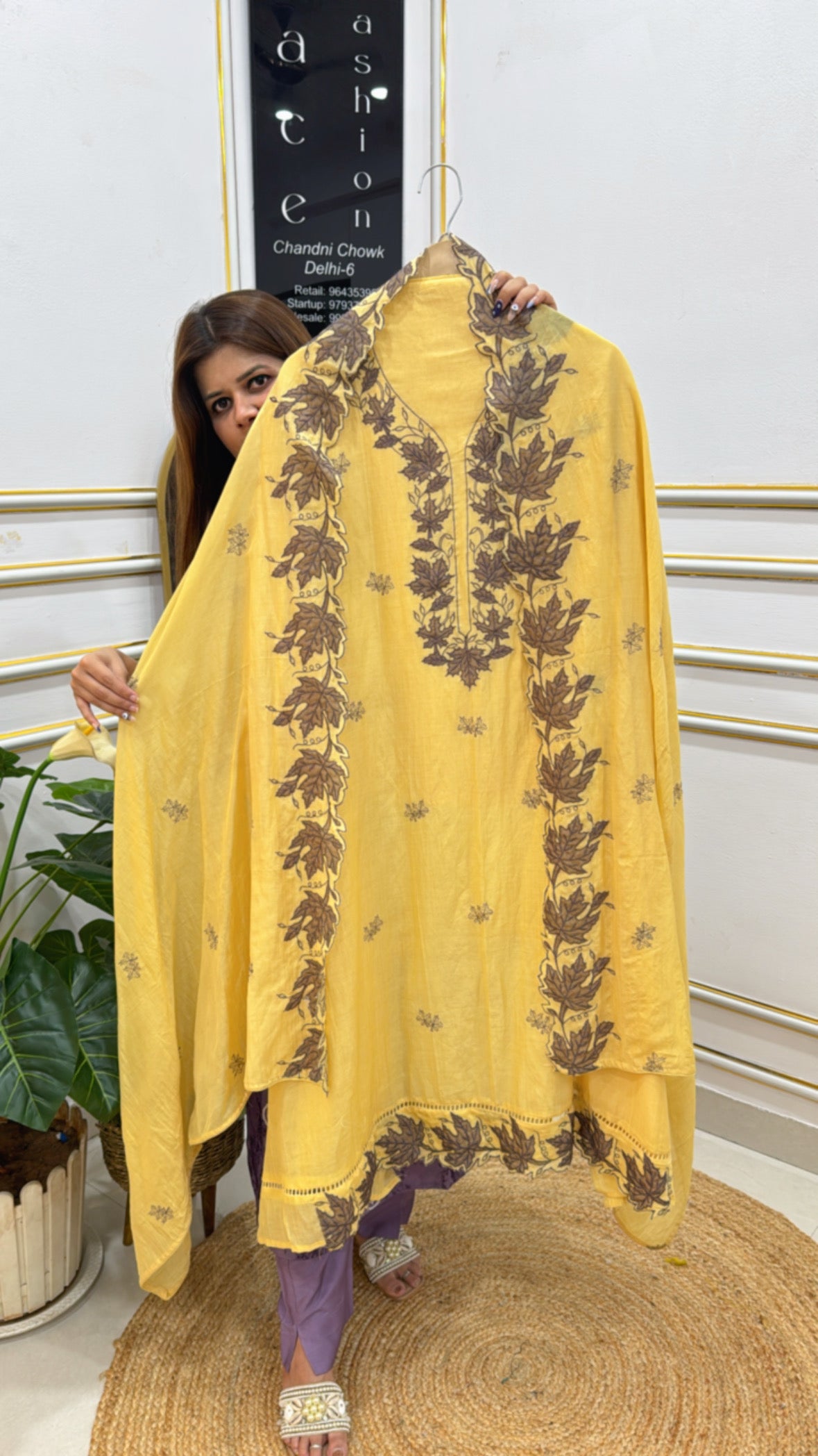 Premium embroidered ladies suits in yellow with floral designs showcased on a model for elegant wear