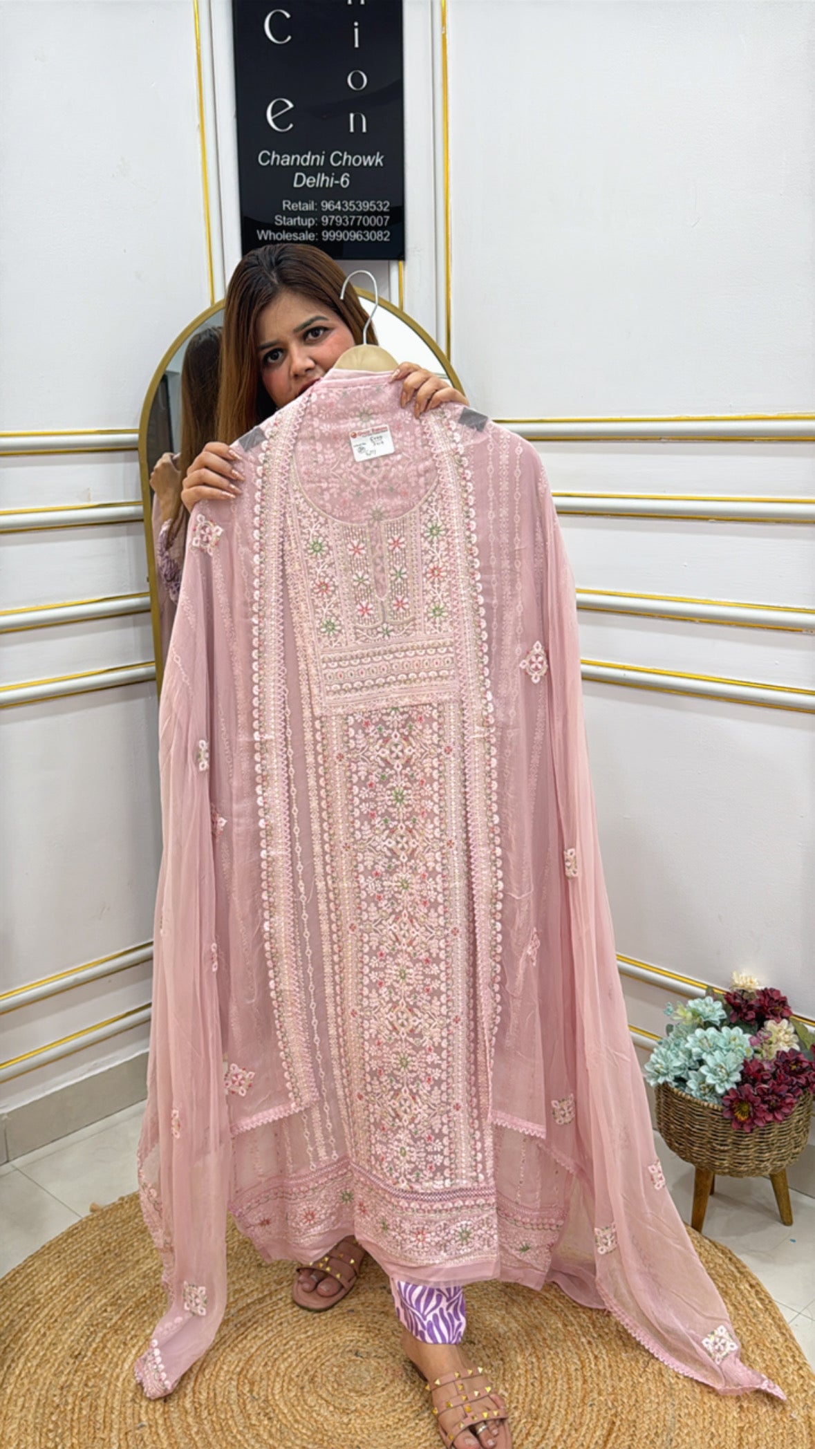 Woman showcasing a Premium Lucknowi Georgette Suit in soft pink with intricate embroidery details