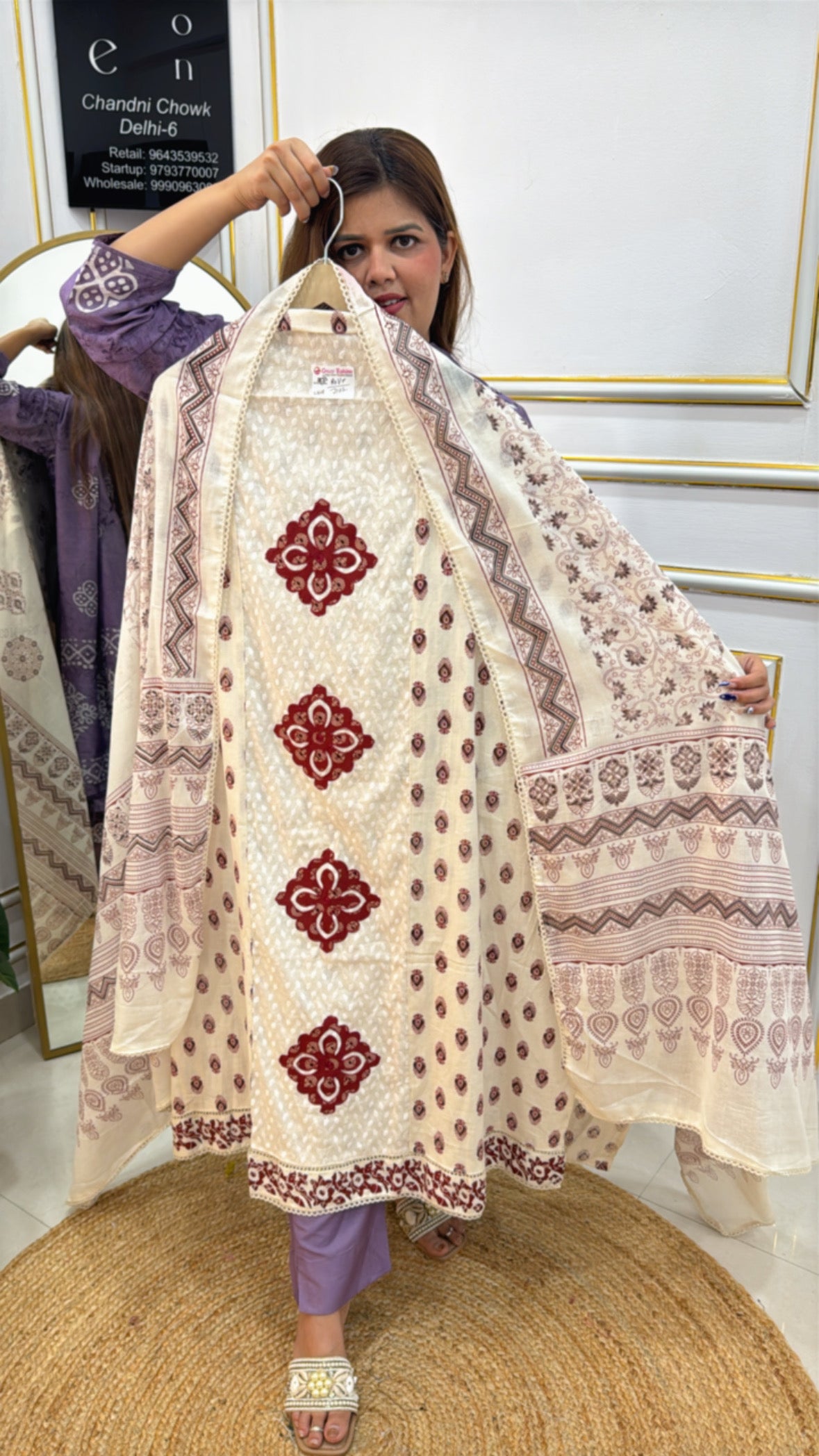 Model showcasing a stylish pure cotton applique suit with intricate designs in elegant beige tones