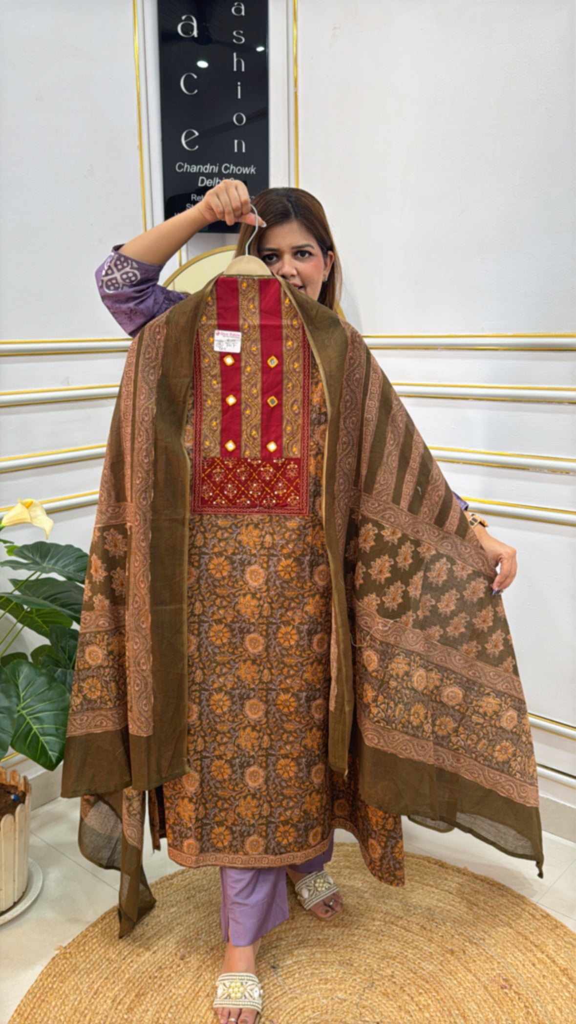 Woman wearing a brown and red ethnic dress with floral patterns from The Grace Fashion boutique