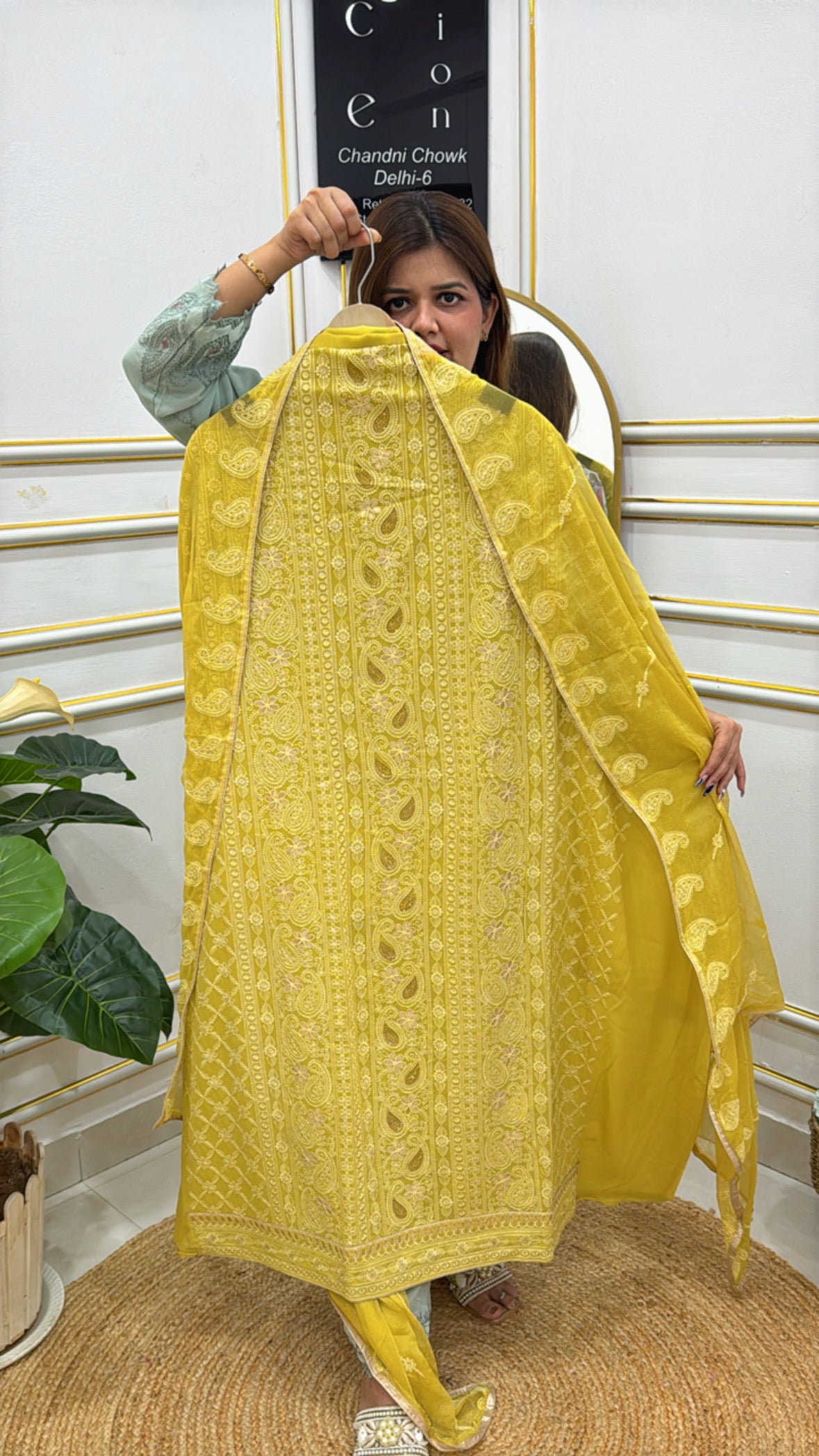Model displaying a vibrant yellow unstitched Lucknowi suit with intricate embroidery and matching dupatta